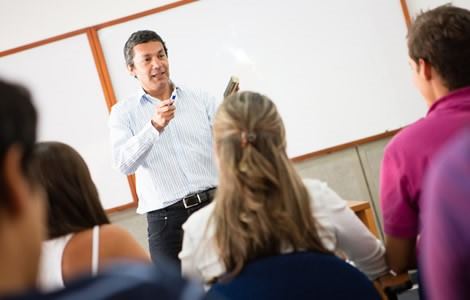 Profesor dando clases. Los estudiantes están de mirando hacia el frente